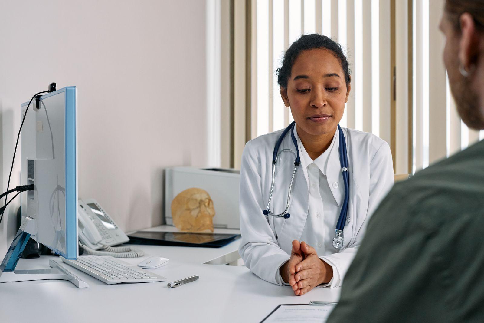 Doctor consulting with a patient across a desk in a modern medical office